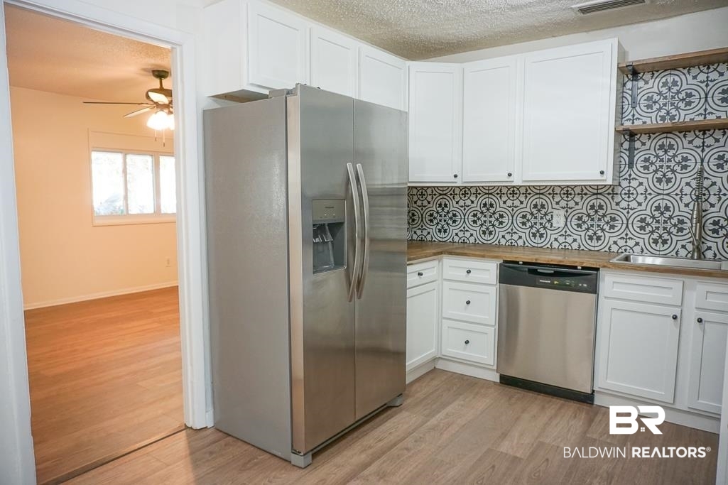 4159 Rebecca Road Mobile, AL 36609 - Photo 8 of 19 Kitchen with stainless steel appliances, white cabinets, a sink, and open shelves