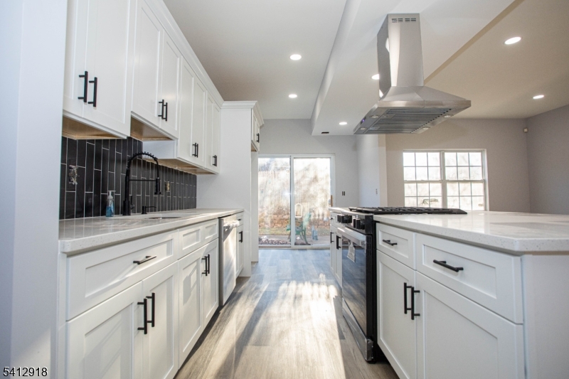 267 Perry Avenue Union, NJ 07083 - Photo 16 of 46 a kitchen with stainless steel appliances kitchen island granite countertop a stove a sink and white cabinets with wooden floor
