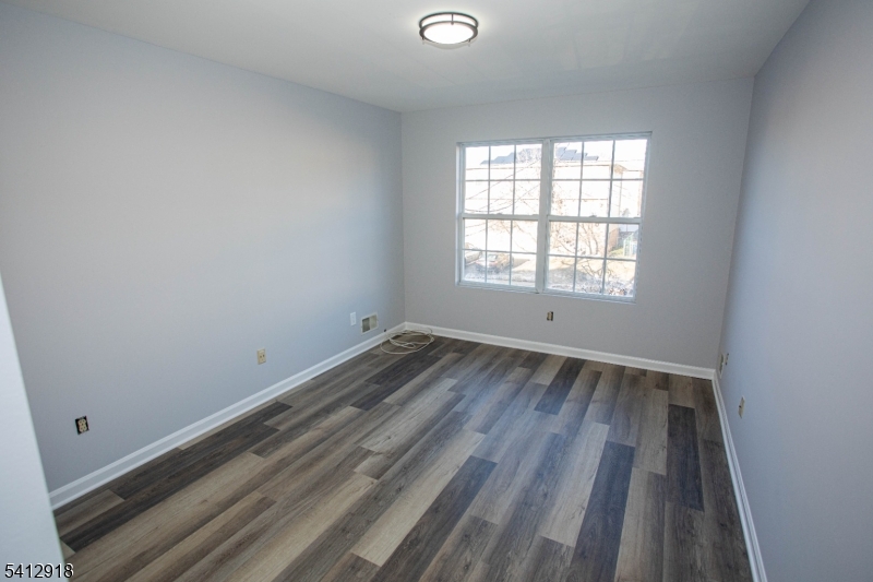 267 Perry Avenue Union, NJ 07083 - Photo 30 of 46 an empty room with wooden floor and windows