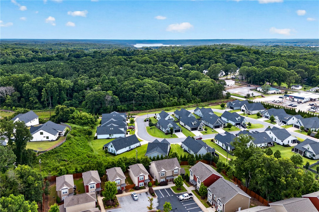 235 Pendleton Road, Unit K1 Clemson, SC 29631 - Photo 43 of 49 An aerial perspective reveals a vibrant community nestled among verdant trees and a distant body of water.