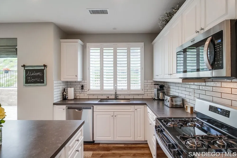 8532 Boulder Way Santee, CA 92071 - Photo 15 of 54 a kitchen with stainless steel appliances a sink stove and cabinets