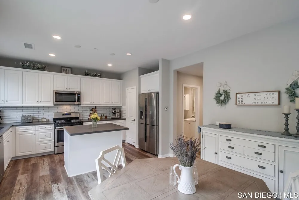 8532 Boulder Way Santee, CA 92071 - Photo 18 of 54 a kitchen with stainless steel appliances kitchen island granite countertop a refrigerator and stove