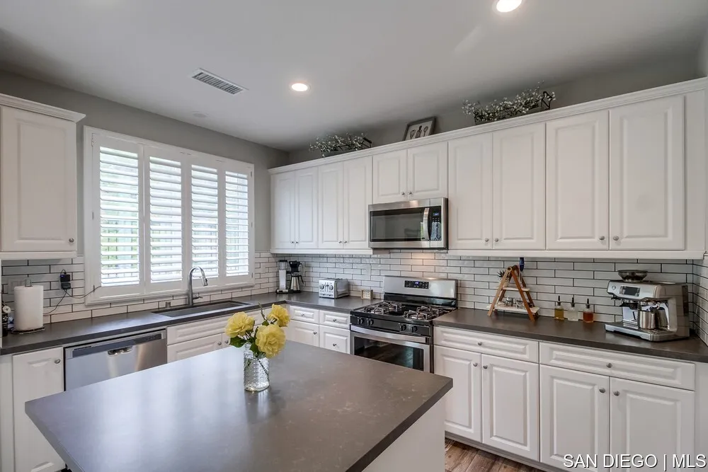 8532 Boulder Way Santee, CA 92071 - Photo 10 of 54 a kitchen with stainless steel appliances granite countertop a sink a stove and a center island