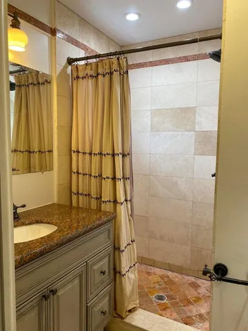 a bathroom with a granite countertop sink a shower and a mirror