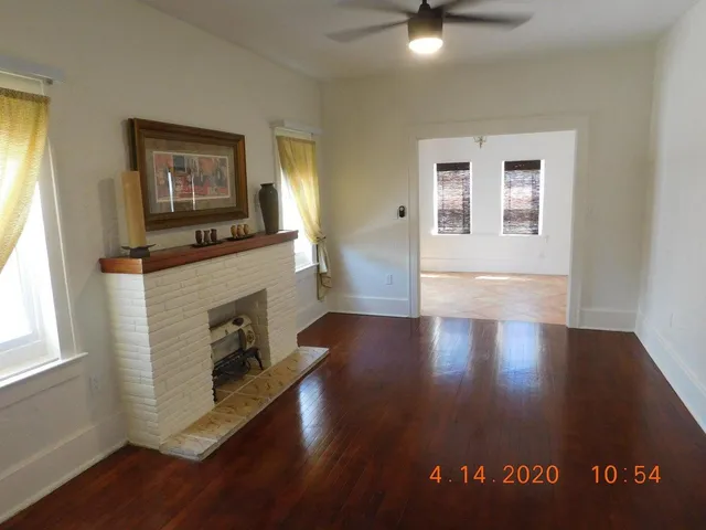 a view of a livingroom with furniture hardwood floor and a fireplace
