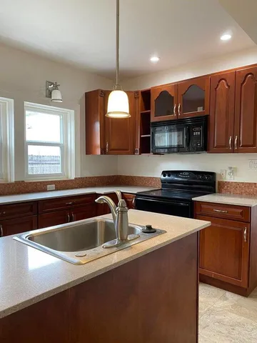 a kitchen with stainless steel appliances granite countertop a sink a stove and a refrigerator