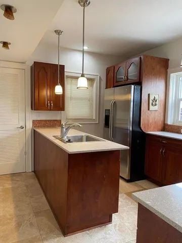 a kitchen with stainless steel appliances granite countertop kitchen island a refrigerator and a sink