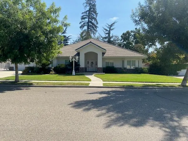 a view of a house with a big yard and large trees
