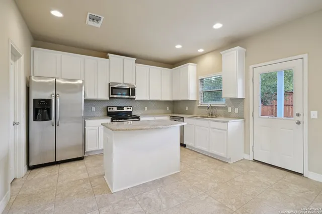 a kitchen with granite countertop cabinets stainless steel appliances and a sink