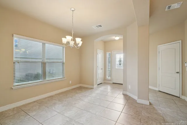 a view of a livingroom with a chandelier fan and windows