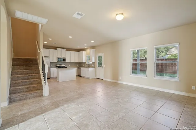 a view of a kitchen with refrigerator and windows