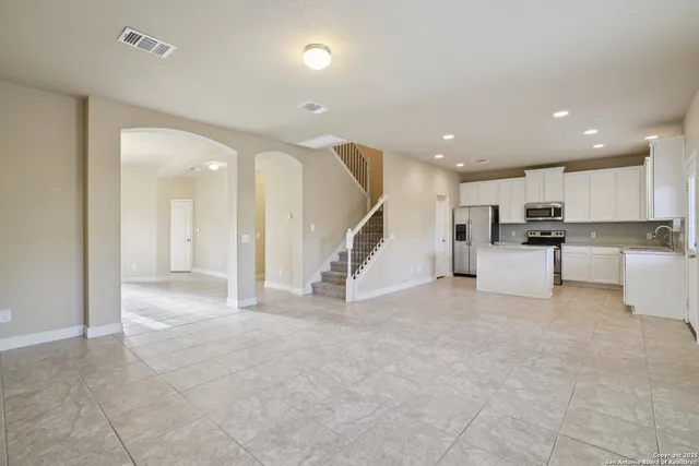 a view of a kitchen with refrigerator and a living room