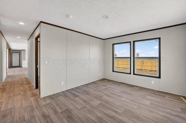 a view of an empty room with window and wooden floor