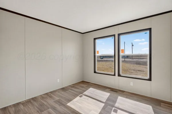 an empty room with wooden floor and a window