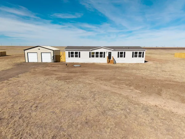 a front view of a house with a garden and yard
