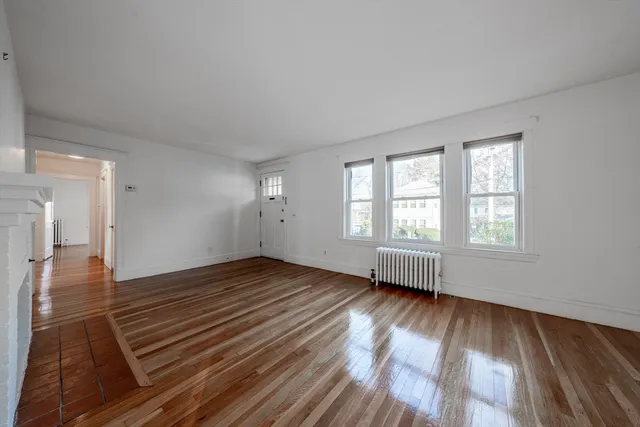 a view of an empty room window and wooden floor