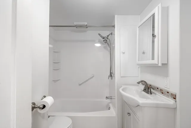a bathroom with a sink a toilet and shower
