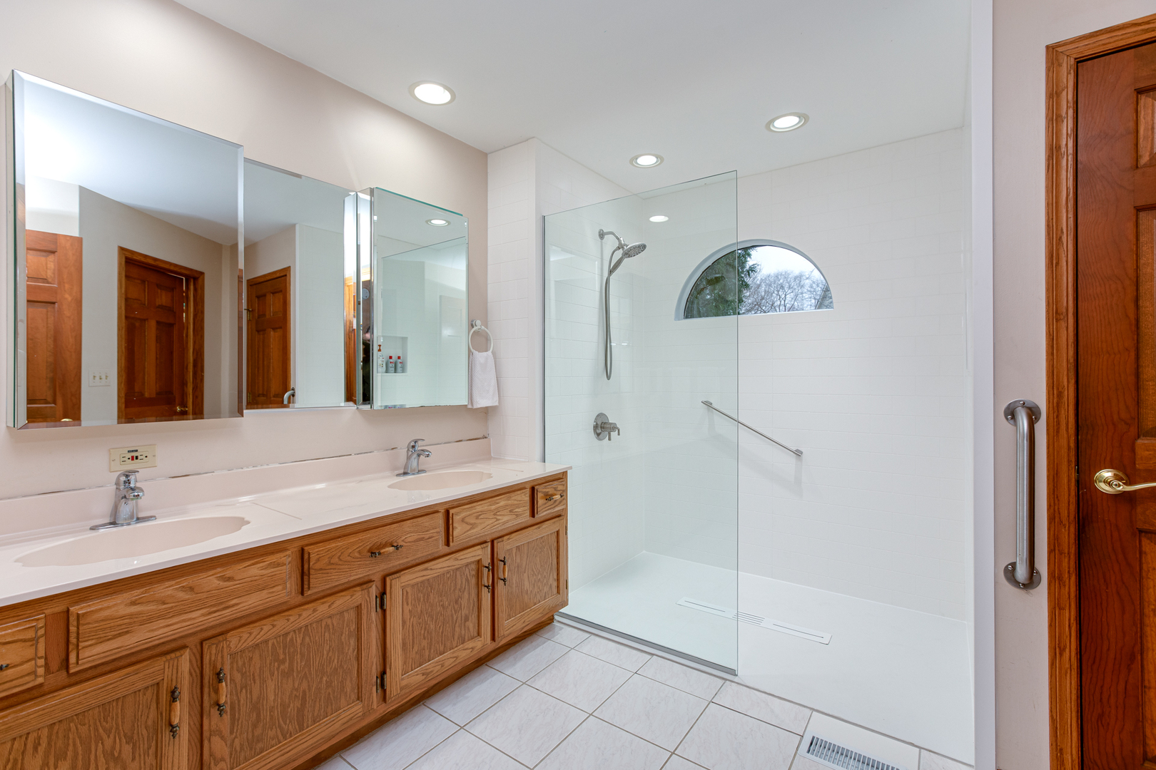 29W220 Oak Knoll Road West Chicago, IL 60185 - Photo 11 of 24 a spacious bathroom with a double vanity sink a large mirror and shower