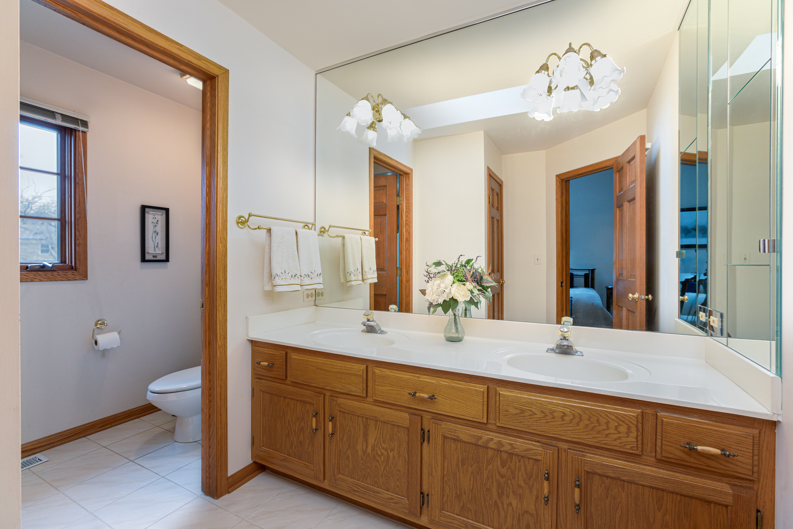 29W220 Oak Knoll Road West Chicago, IL 60185 - Photo 13 of 24 a bathroom with a double vanity sink and a mirror