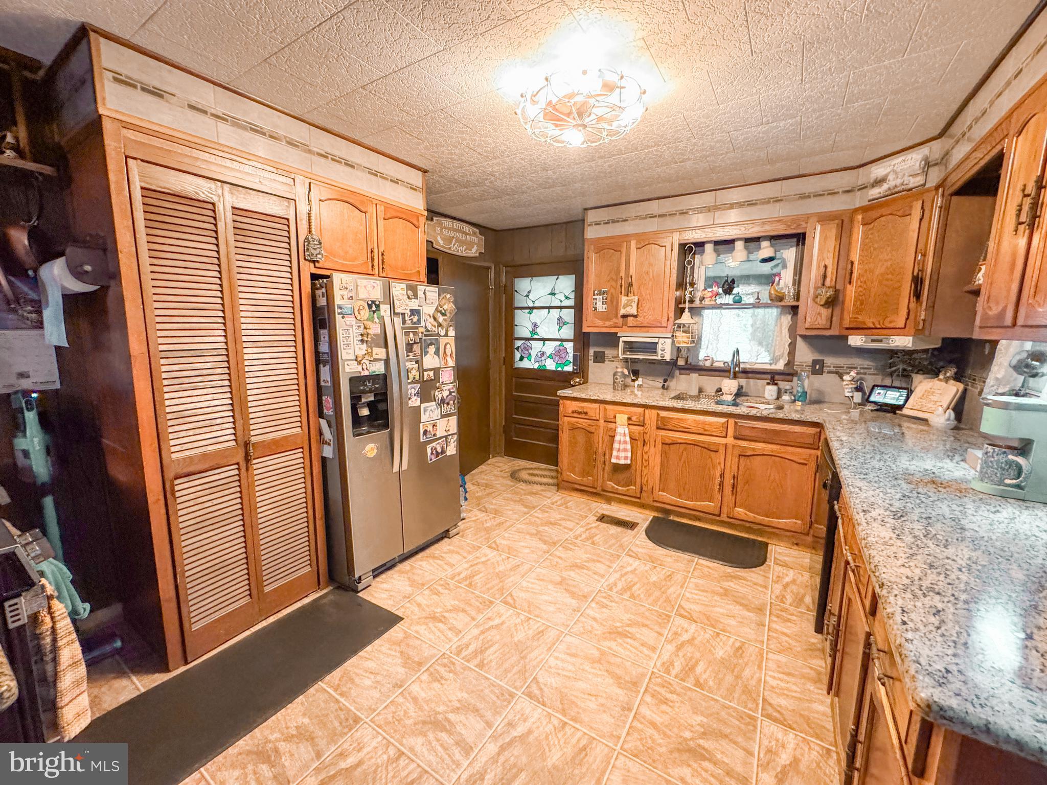 12522 Bakers Hollow Road Hesston, PA 16647 - Photo 5 of 72 a kitchen with stainless steel appliances granite countertop a refrigerator a sink dishwasher a stove and a dining table with wooden floor