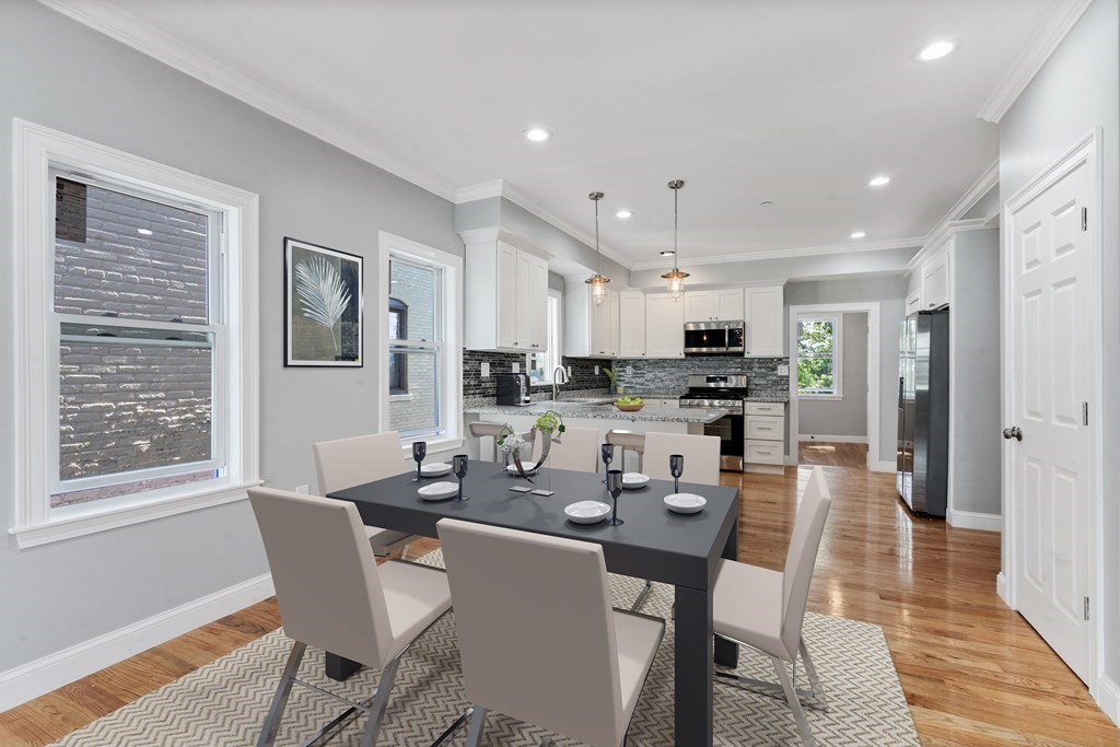 9 Wales Street, Unit 2 Boston, MA 02124 - Photo 3 of 15 a dining room with stainless steel appliances kitchen island granite countertop a dining table chairs and a refrigerator