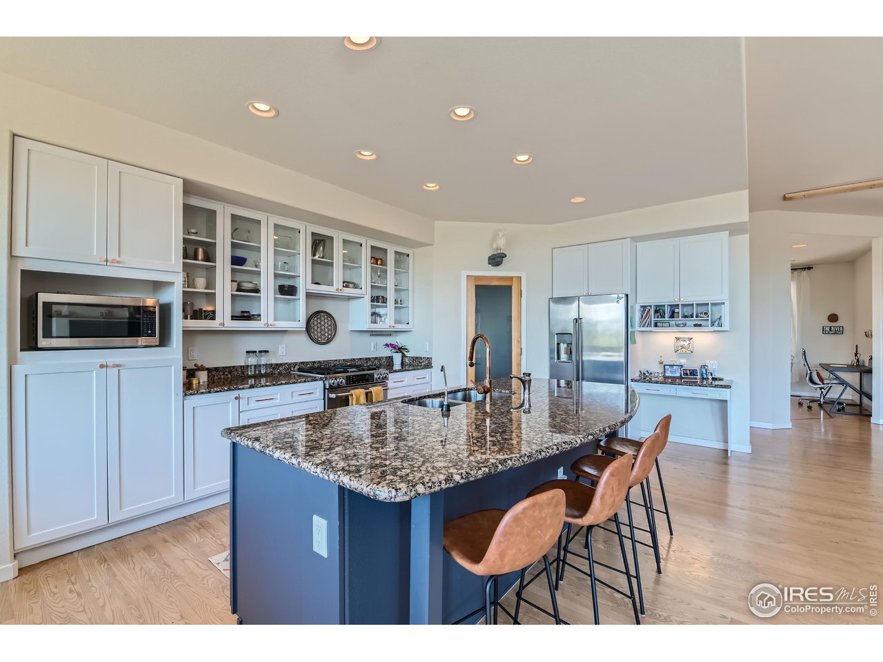 365 Vasquez Court Lyons, CO 80540 - Photo 10 of 40 a kitchen with granite countertop kitchen island stainless steel appliances a refrigerator a sink a stove a table and chairs
