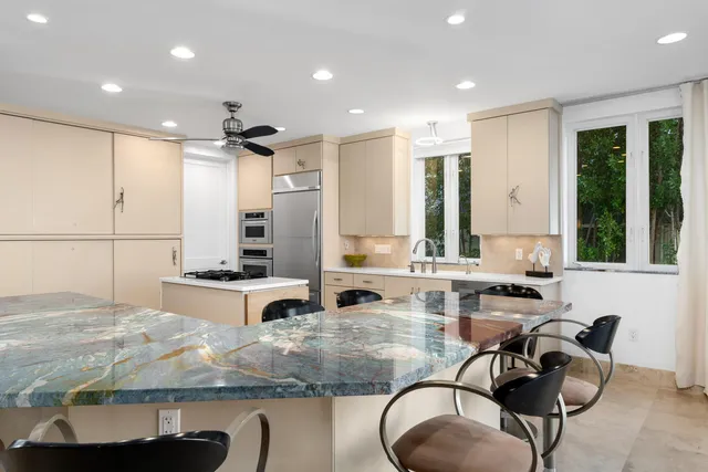 a living room with a large window and chandelier