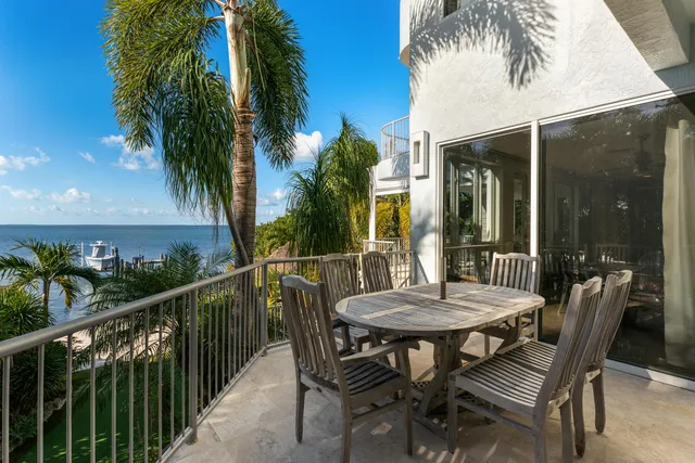 a view of a white house with a yard and potted plants