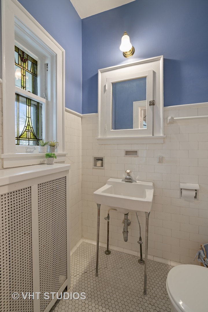 610 Forest Avenue Wilmette, IL 60091 - Photo 42 of 50 a bathroom with a sink a mirror and a toilet