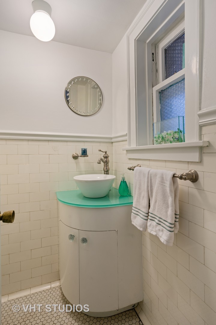 610 Forest Avenue Wilmette, IL 60091 - Photo 43 of 50 a bathroom with a sink and a mirror