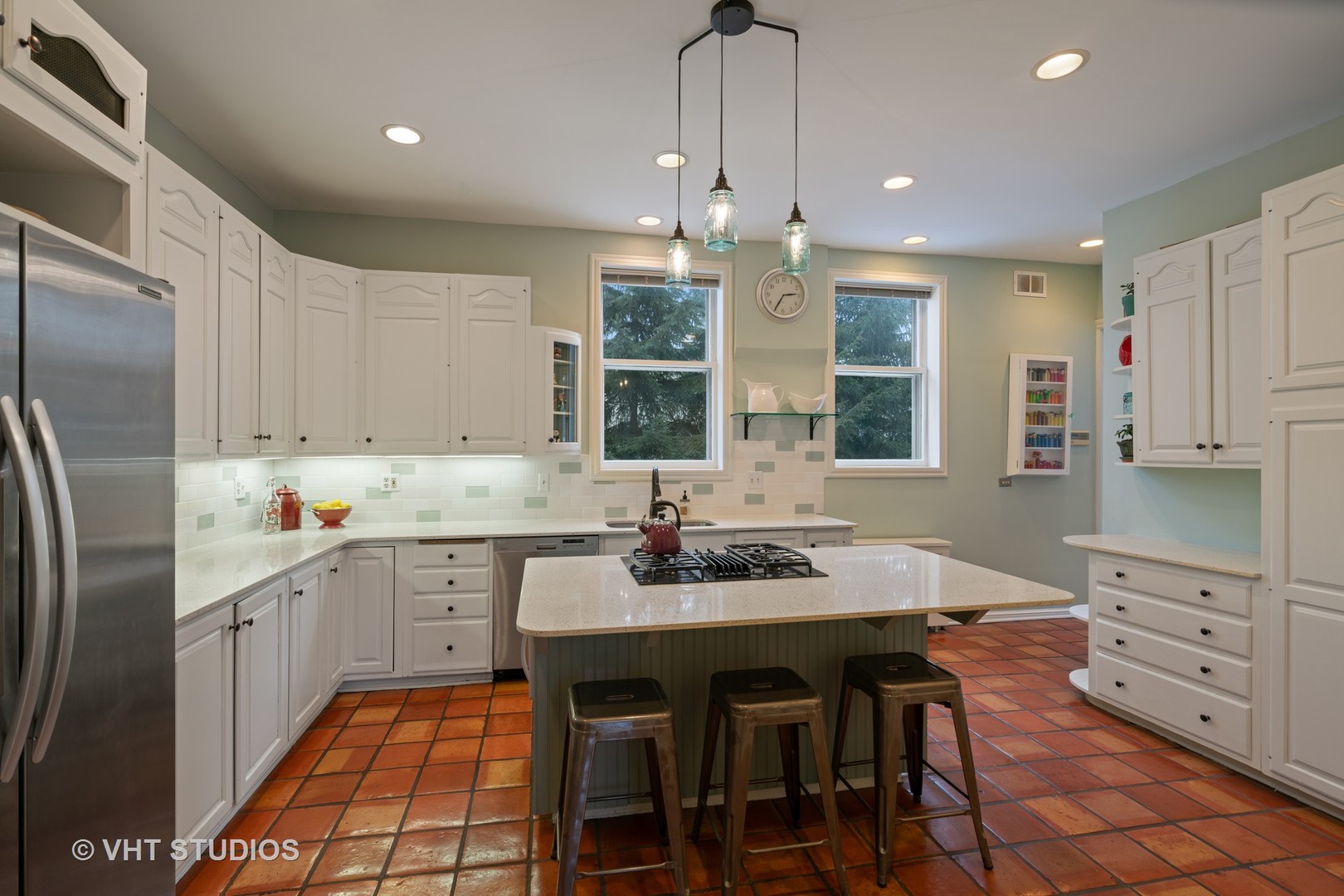 610 Forest Avenue Wilmette, IL 60091 - Photo 10 of 50 a kitchen with stainless steel appliances kitchen island granite countertop a table chairs sink and cabinets