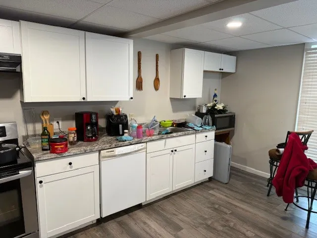 a kitchen with white cabinets and sink