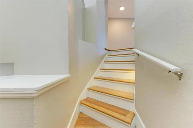 a bedroom with wooden floor and a ceiling fan
