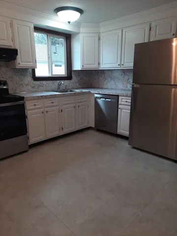 a kitchen with a white cabinets and white appliances