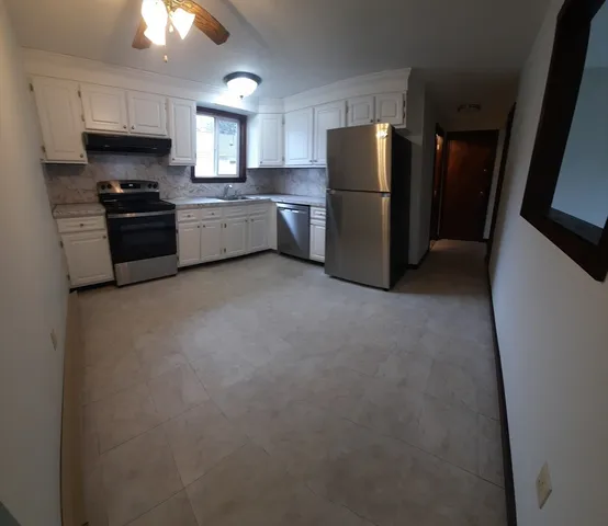 a kitchen with refrigerator a microwave a sink and cabinets