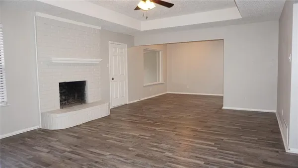 a view of empty room with wooden floor and fireplace