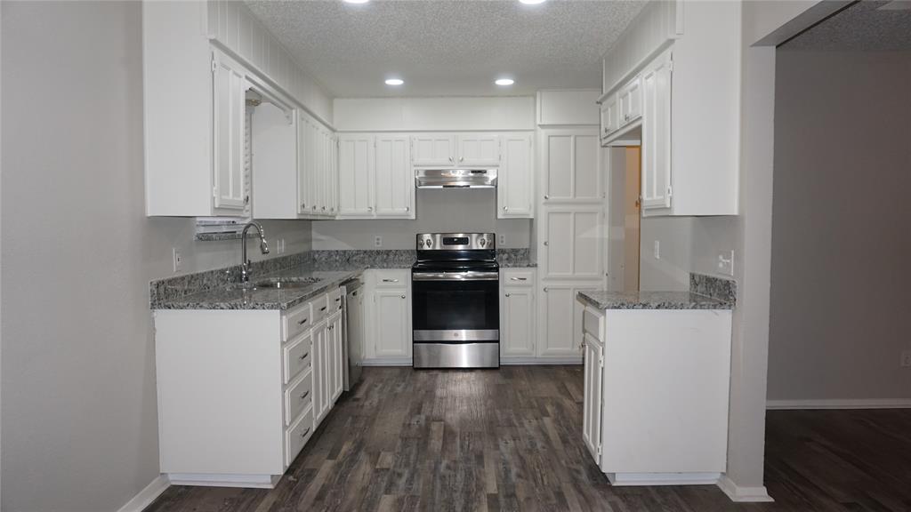 6412 Fairview Drive Watauga, TX 76148 - Photo 5 of 14 a kitchen with granite countertop a refrigerator and white cabinets