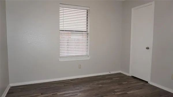 an empty room with wooden floor and a window