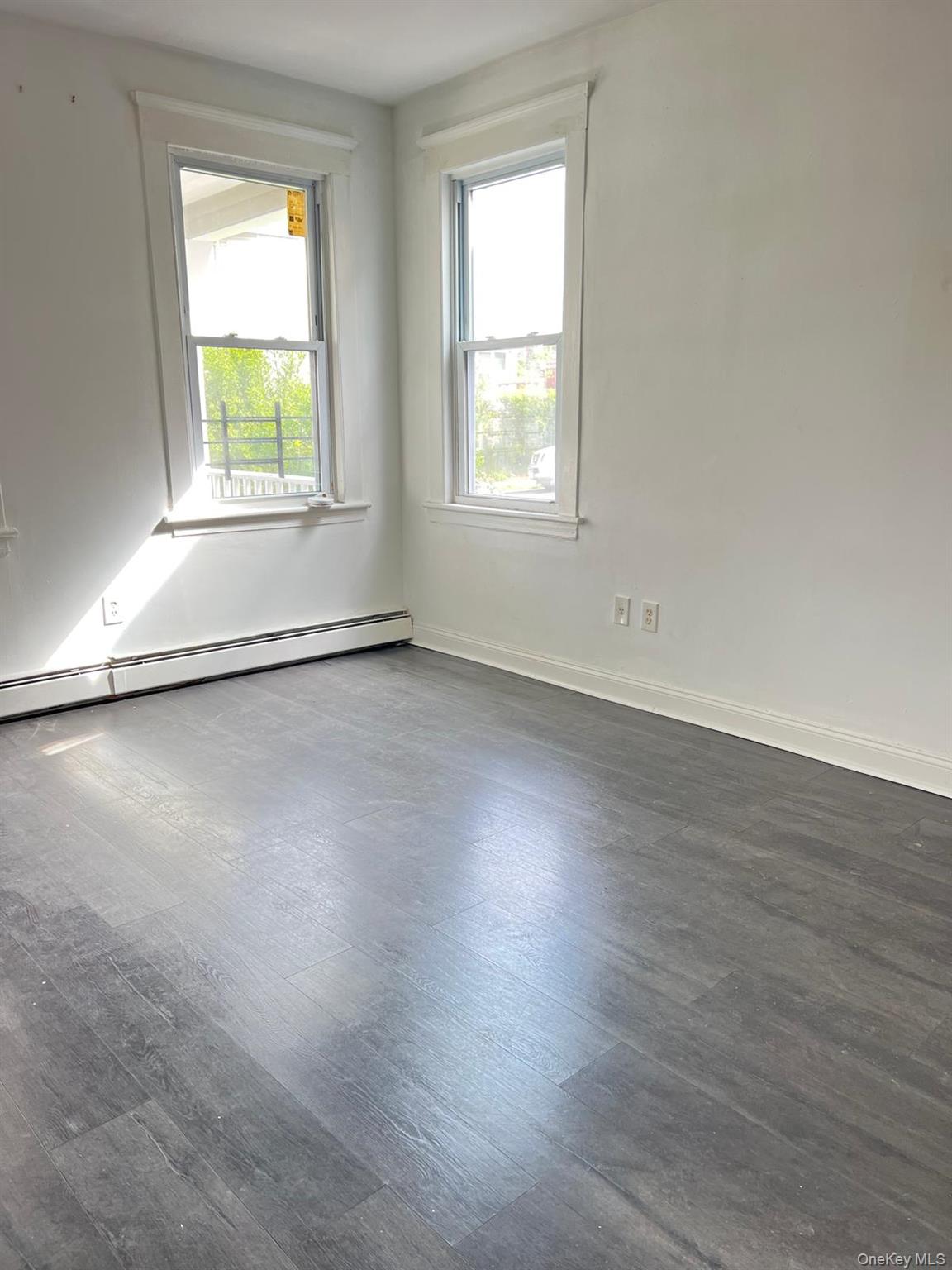72 Chauncey Avenue New Rochelle, NY 10801 - Photo 2 of 7 an empty room with wooden floor and windows