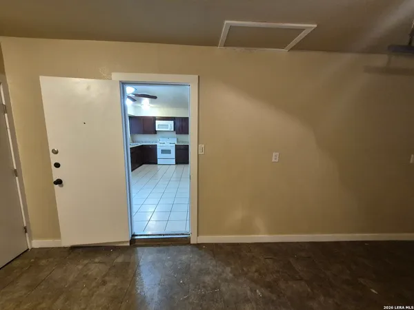 a view of a hallway with wooden floor and a bathroom