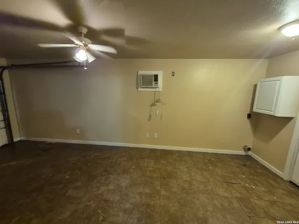 a view of a hallway with wooden floor and a ceiling fan