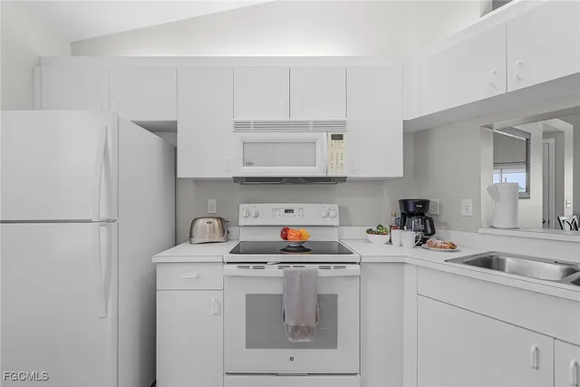 a kitchen with white cabinets and sink