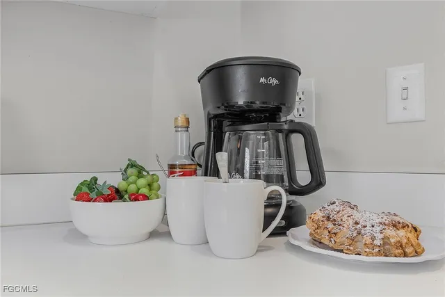 a dining room with furniture a potted plant and wooden floor