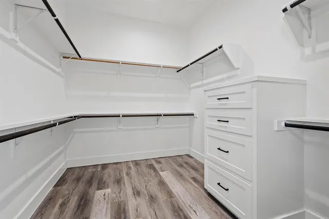 an empty room with windows and wooden floor