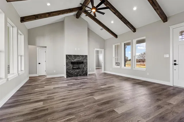 a view of a livingroom with wooden floor a fireplace and window