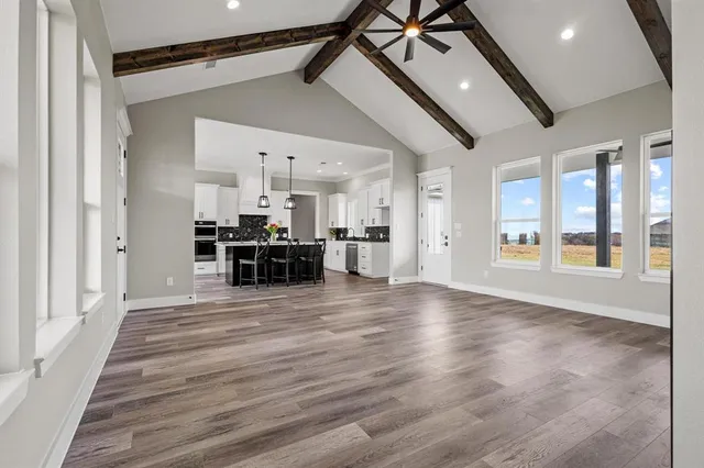 a kitchen with stainless steel appliances kitchen island granite countertop a table chairs stove and white cabinets