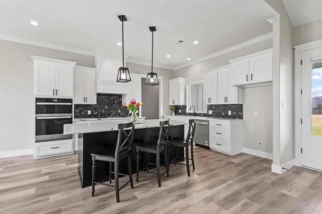 a kitchen with a sink stainless steel appliances and white cabinets