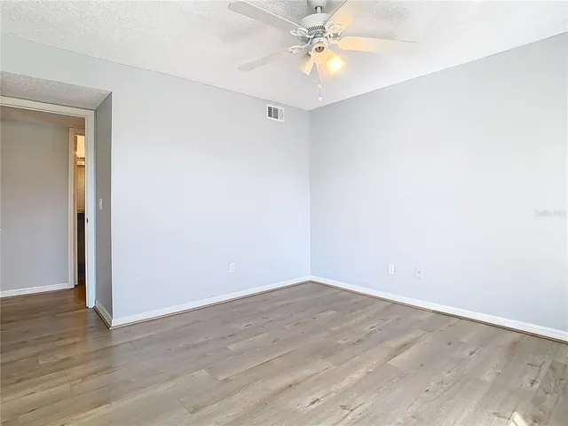 a view of an empty room with wooden floor