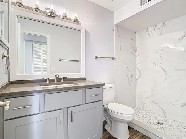 a bathroom with a sink a toilet and shower