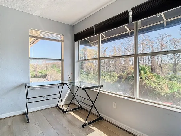 a view of a room with wooden floor and windows